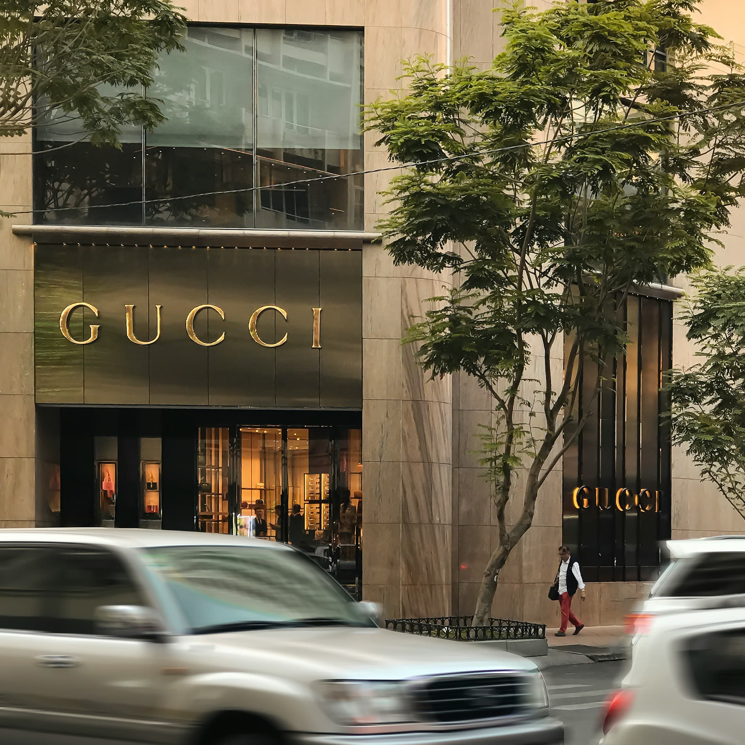 Gucci flagship storefront with gold lettering on a marble facade in a luxury shopping district