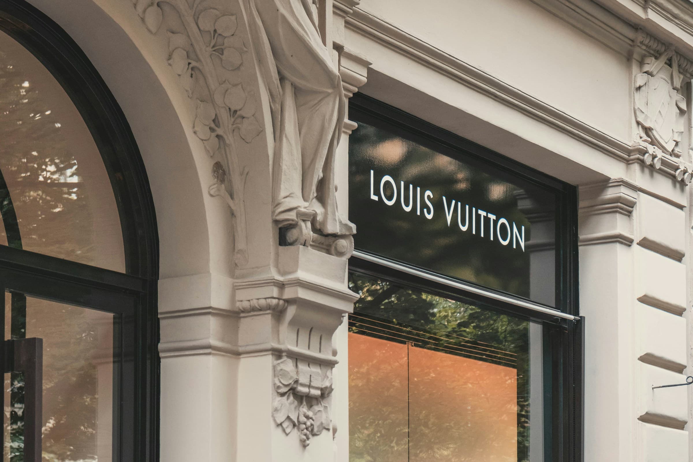 Louis Vuitton boutique signage on a neoclassical stone building facade